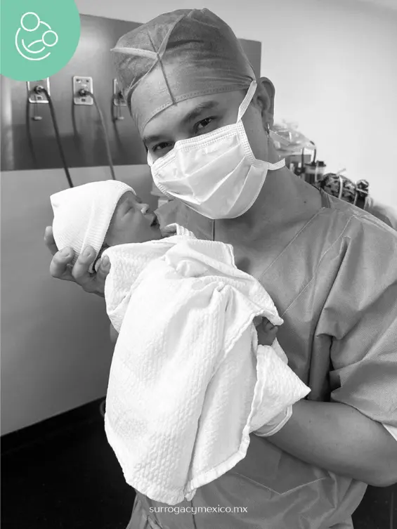 New father holding his newborn baby wrapped in a white blanket at the hospital, a beautiful moment made possible through Surrogacy Mexico.