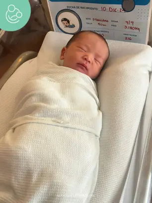 Newborn baby wrapped in a white blanket at a hospital crib in Mexico, part of a surrogacy birth through Surrogacy Mexico